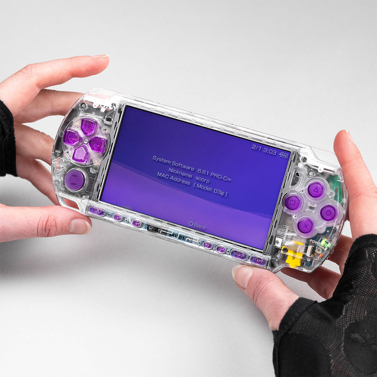 Front view of clear PSP-3000 mod with violet buttons and transparent body. Minimalist aesthetic highlighting the clean internal build by PlayingScorp.