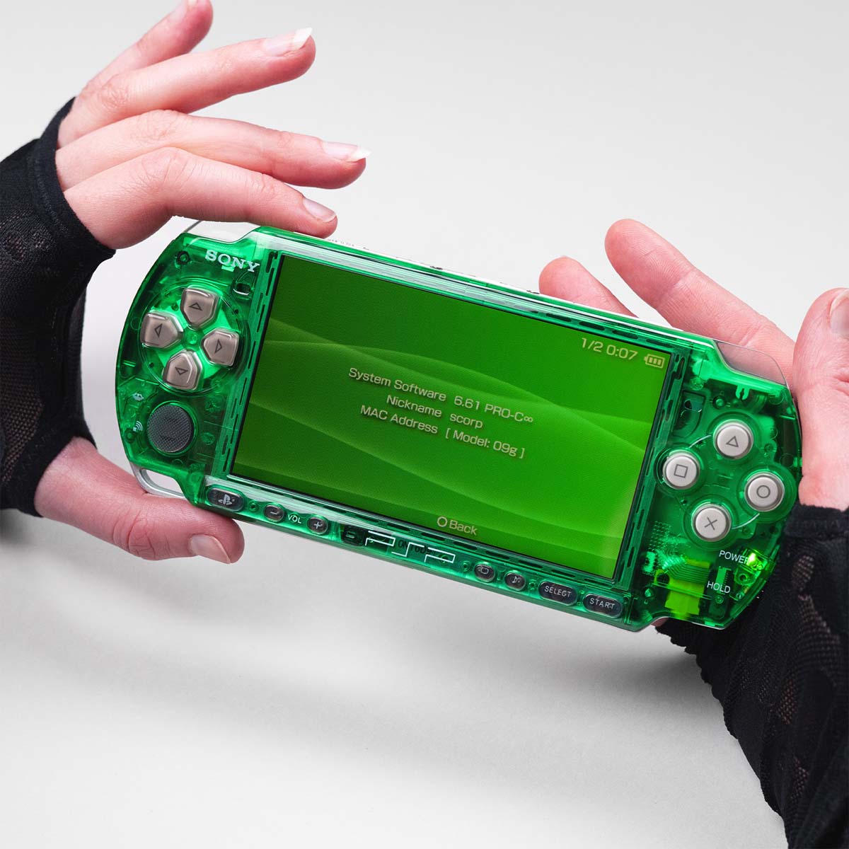 Modded green transparent PSP with white buttons running firmware 6.61 PRO-C, held in hands with green system menu displayed on screen