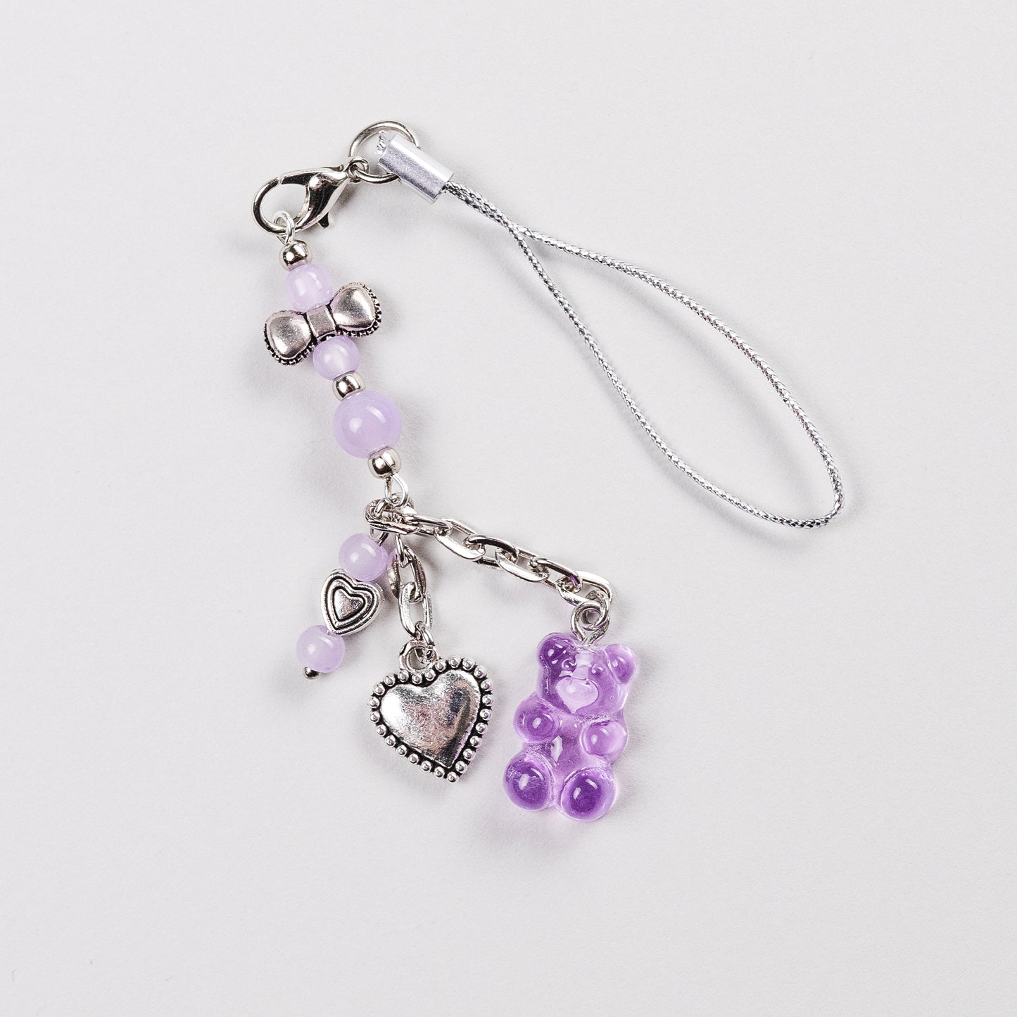 Cute kawaii charm strap with purple beads, silver bow, heart pendants, and a translucent gummy bear – perfect for PSP, phone, or handheld consoles