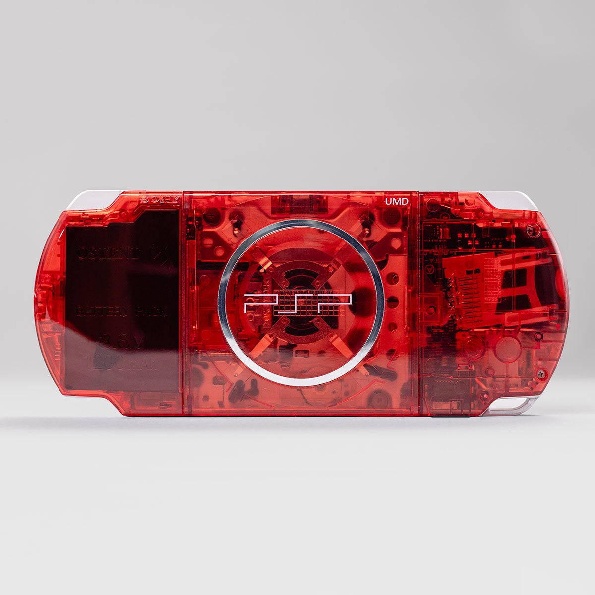 "Transparent red back shell of Sony PSP 3000 handheld console custom mod housing with visible UMD drive and battery cover