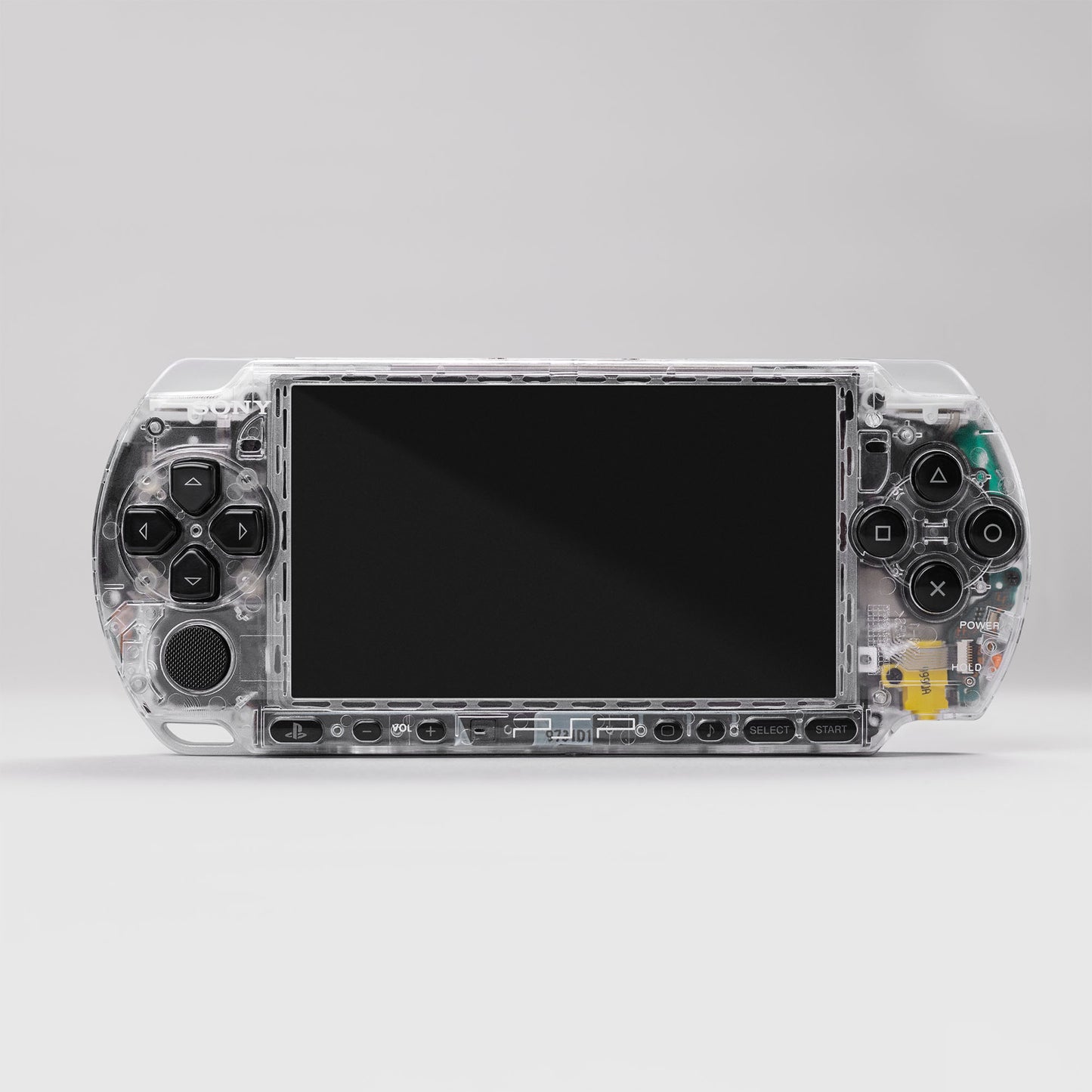 Front view of a transparent Sony PSP handheld gaming console with visible internal components and classic control buttons