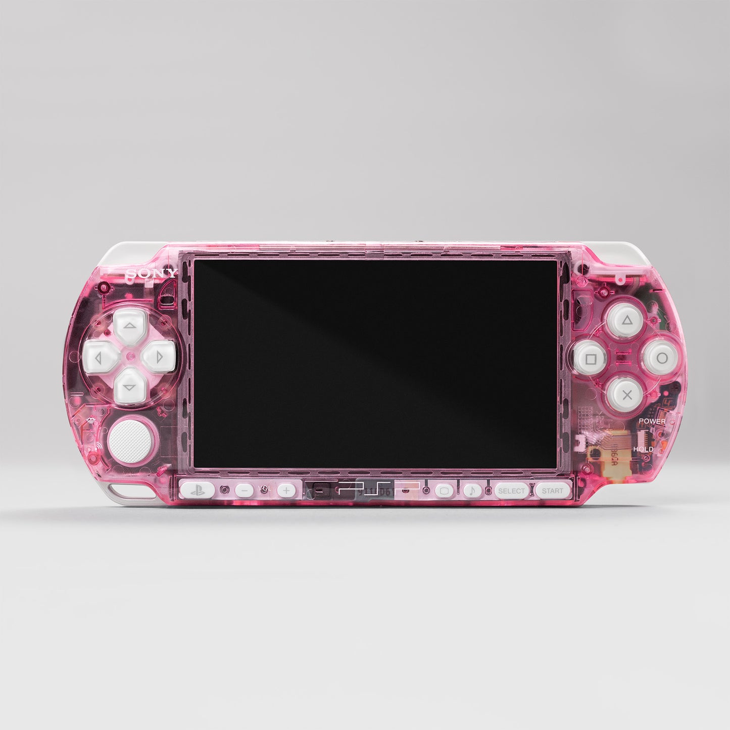 Front view of a Sony PSP handheld console with a custom pink transparent shell and white control buttons, featuring a clear modded design
