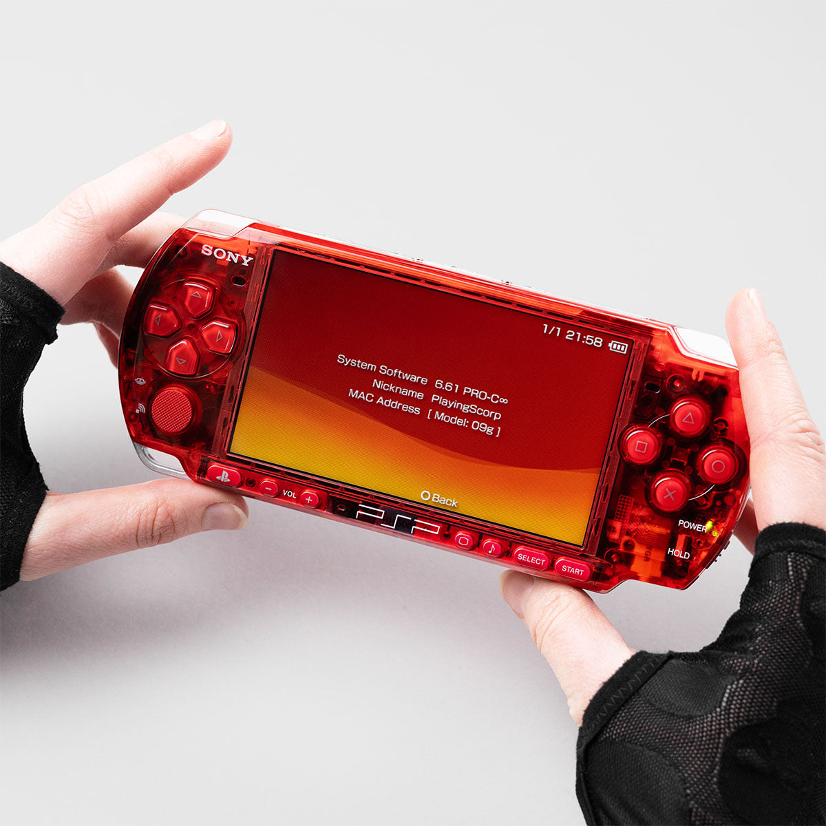 Sony PSP 3000 handheld gaming console in transparent red custom shell, refurbished with upgraded controls and clear front buttons, shown front view.”