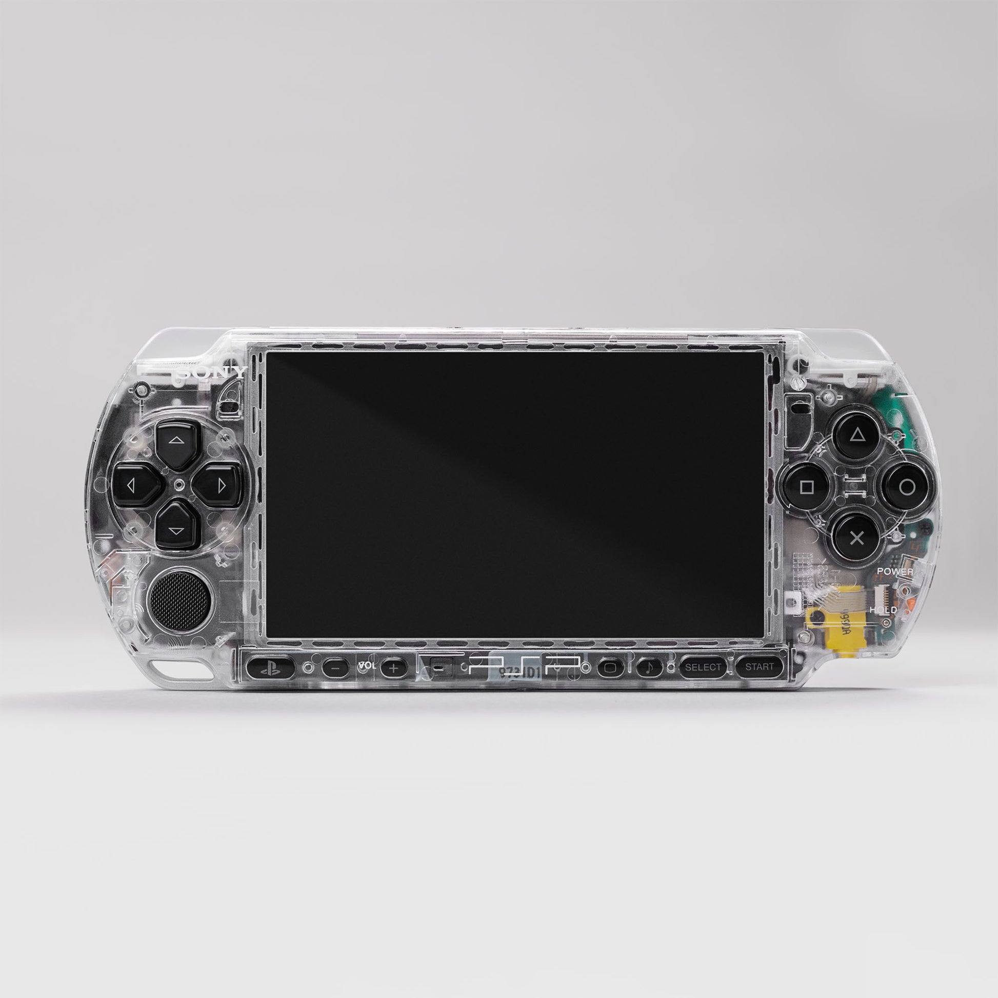 Front view of a transparent Sony PSP handheld gaming console with visible internal components and classic control buttons